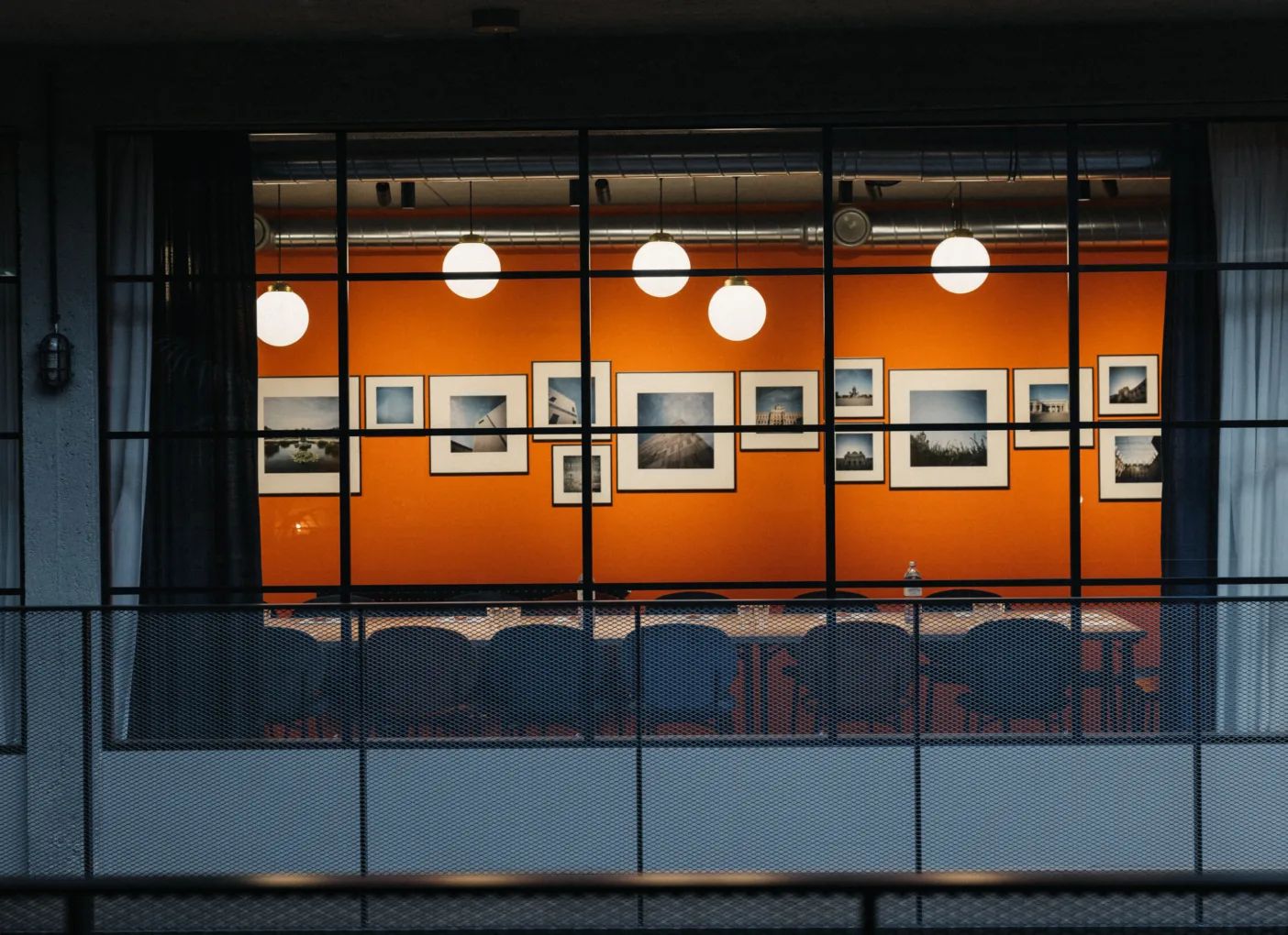 Büro mit orangefarbener Wand und Bildern